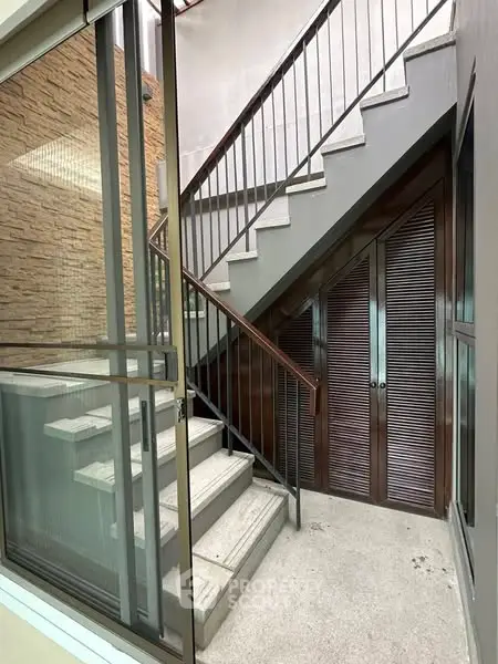 Modern staircase with sleek metal railings and glass accents in a contemporary building.