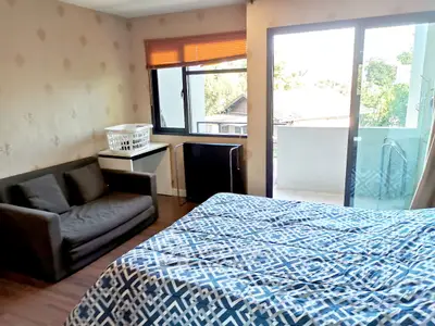Spacious bedroom with balcony access and cozy seating area.
