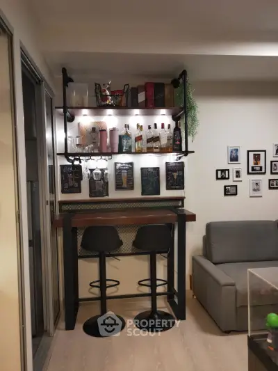 Stylish home bar setup with shelves, stools, and wall decor in a cozy living room corner.
