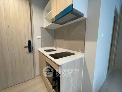 Modern compact kitchen with sleek cabinetry and built-in appliances in a stylish apartment.