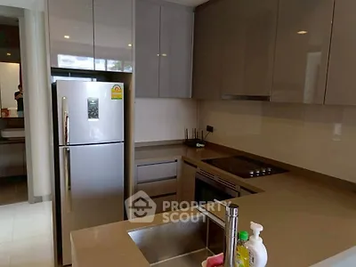 Modern kitchen with sleek cabinetry and stainless steel appliances in a contemporary apartment.