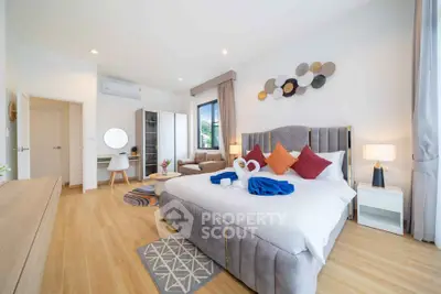 Spacious modern bedroom with elegant decor and cozy seating area