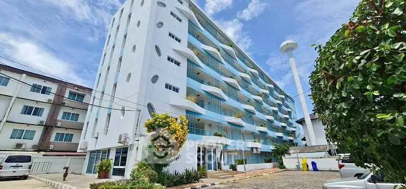 Modern multi-story building with unique architectural design and spacious balconies.