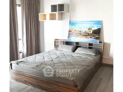 Modern bedroom with stylish decor and large window for natural light.