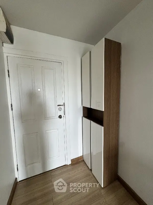 Compact entryway with sleek storage cabinets and wooden flooring