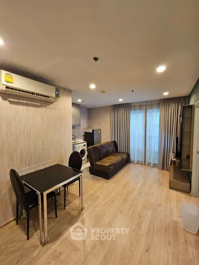 Modern living room with dining area and washing machine, featuring stylish decor and natural light.