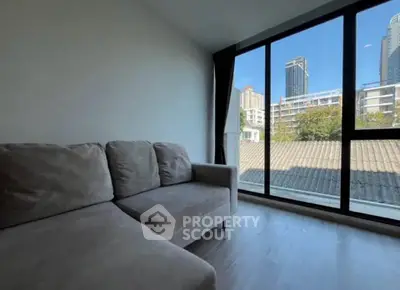 Modern living room with large windows offering city skyline view