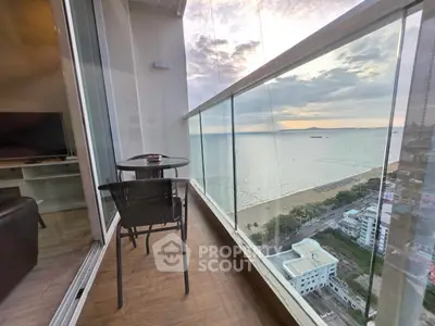 Stunning high-rise balcony with panoramic ocean view and cozy seating area.