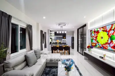 Modern open-plan living room with stylish decor and large TV