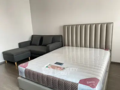 Modern bedroom with stylish bed and cozy sofa in a minimalist design