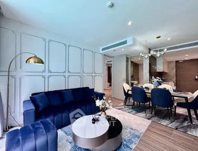 Luxurious modern living room with elegant blue furniture and stylish dining area, perfect for sophisticated urban living.