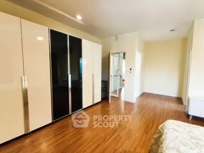 Spacious bedroom with modern wardrobe and wooden flooring