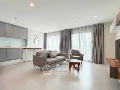 Spacious modern living room with stylish furniture and large windows in a contemporary apartment.