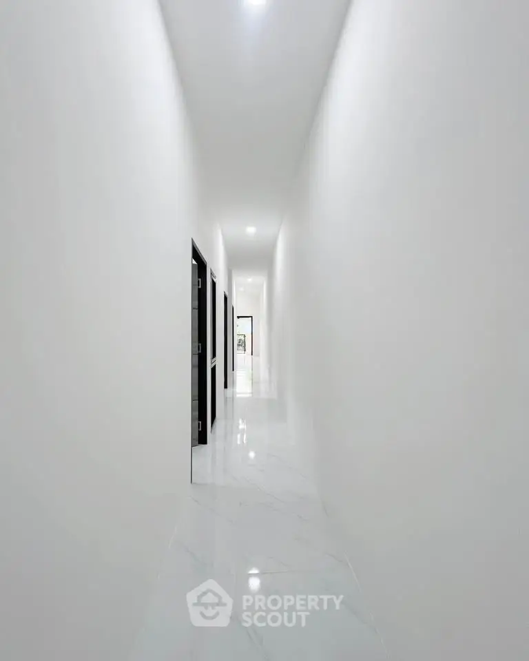 Sleek modern corridor with glossy white marble flooring and minimalist design.