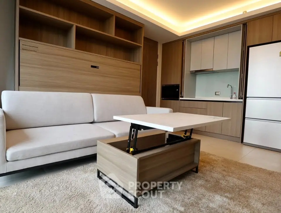 Modern living room with sleek furniture and open kitchen layout in a stylish apartment.