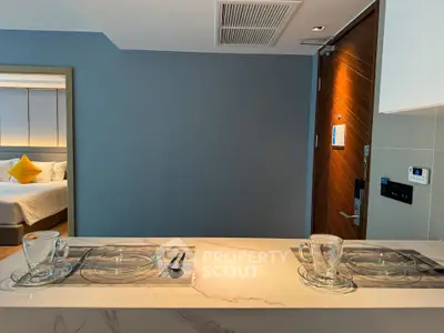 Modern kitchen with breakfast bar and view into cozy bedroom