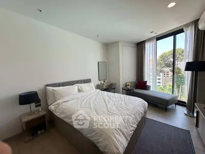 Modern bedroom with large window and stylish decor, offering a serene and comfortable living space.
