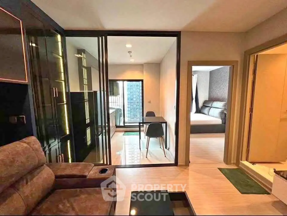 Modern apartment interior with glass partition, cozy living area, and stylish bedroom.