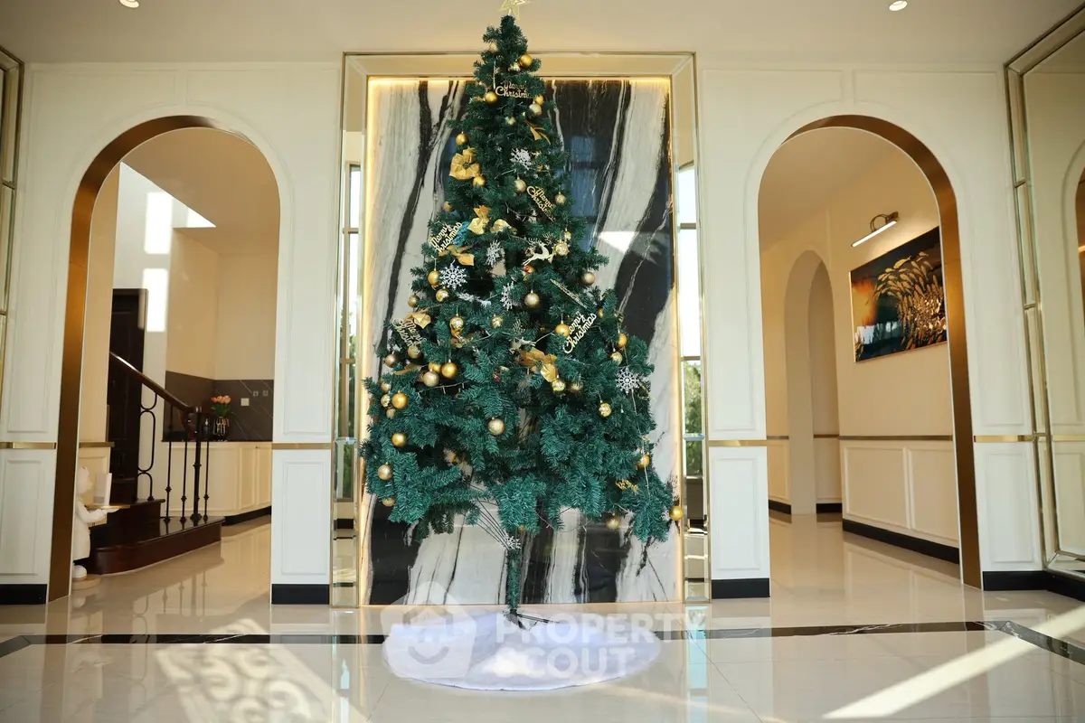 Luxurious home entrance with elegant Christmas tree and marble accents
