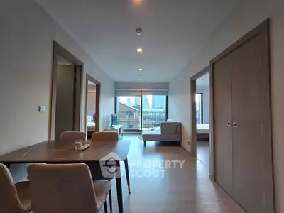 Modern apartment interior with open living and dining area, featuring city view.