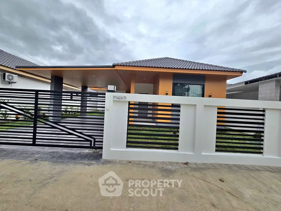 Modern single-story house with sleek design and spacious driveway in a serene neighborhood.