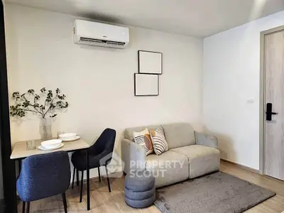 Modern living room with cozy sofa and dining area, featuring minimalist decor and air conditioning.