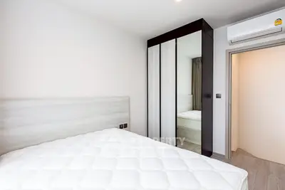 Modern bedroom with sleek wardrobe and air conditioning in a stylish apartment.