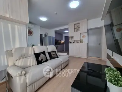 Modern living room with cozy sofa and sleek kitchen in open layout apartment.