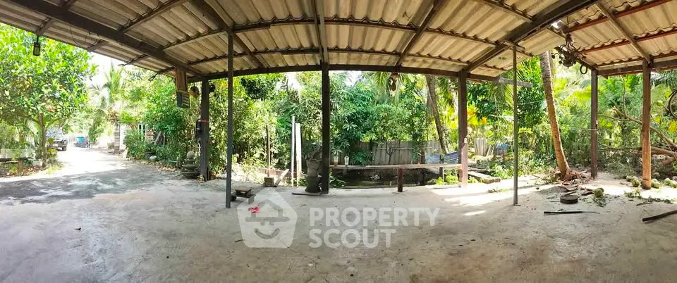 Spacious outdoor area with lush greenery and open roof structure, ideal for garden enthusiasts.