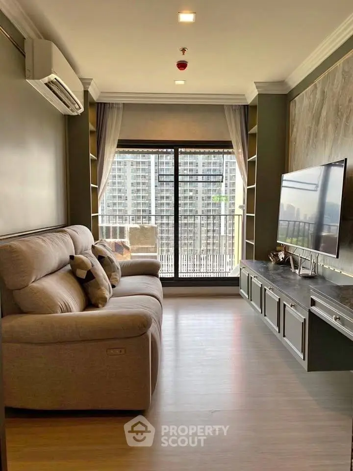 Modern living room with large window and city view, featuring cozy sofa and sleek entertainment unit.