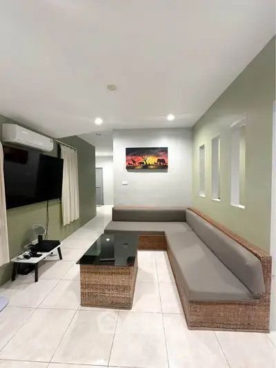 Modern living room with stylish wicker furniture and wall-mounted TV