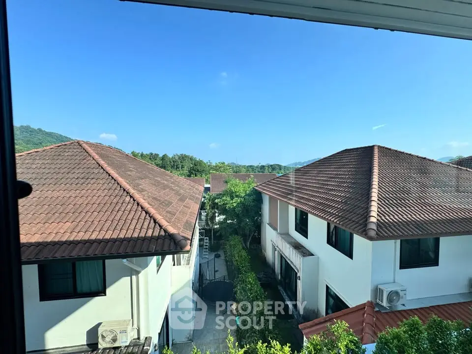 Stunning view of modern suburban homes with red-tiled roofs and lush greenery, perfect for serene living.