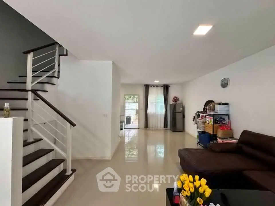 Spacious modern living room with sleek staircase and natural light