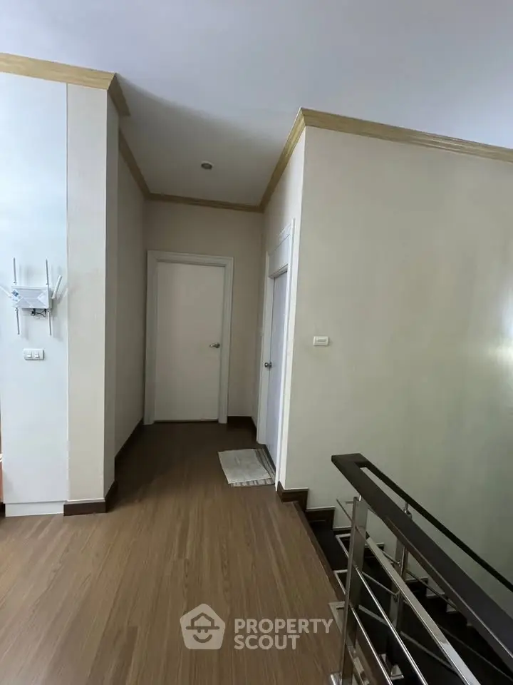 Stylish hallway with modern wooden flooring and elegant staircase