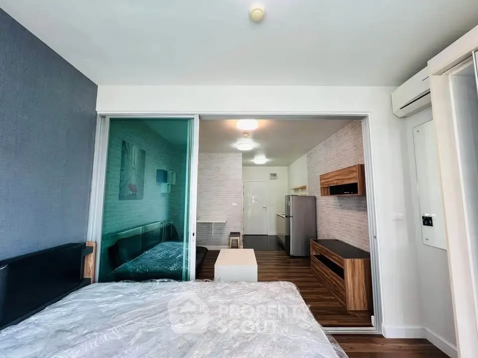 Modern studio apartment with open layout and stylish furnishings, featuring a cozy living area and sleek kitchen.