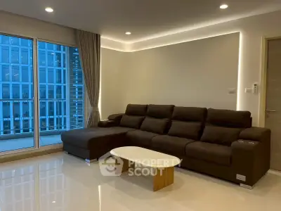 Modern living room with sleek sofa and city view from large windows.