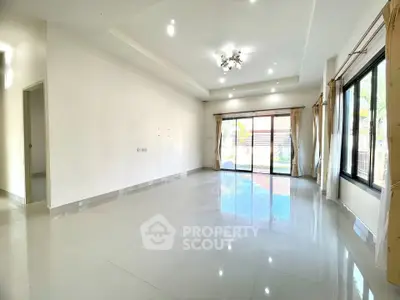 Spacious empty living room with large windows and glossy tiled floors