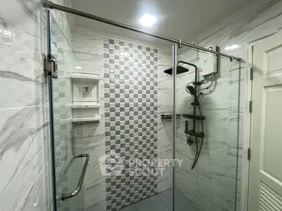 Modern bathroom with glass shower enclosure and stylish tile design