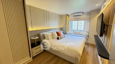 Luxurious modern bedroom with elegant decor and large window seating area.