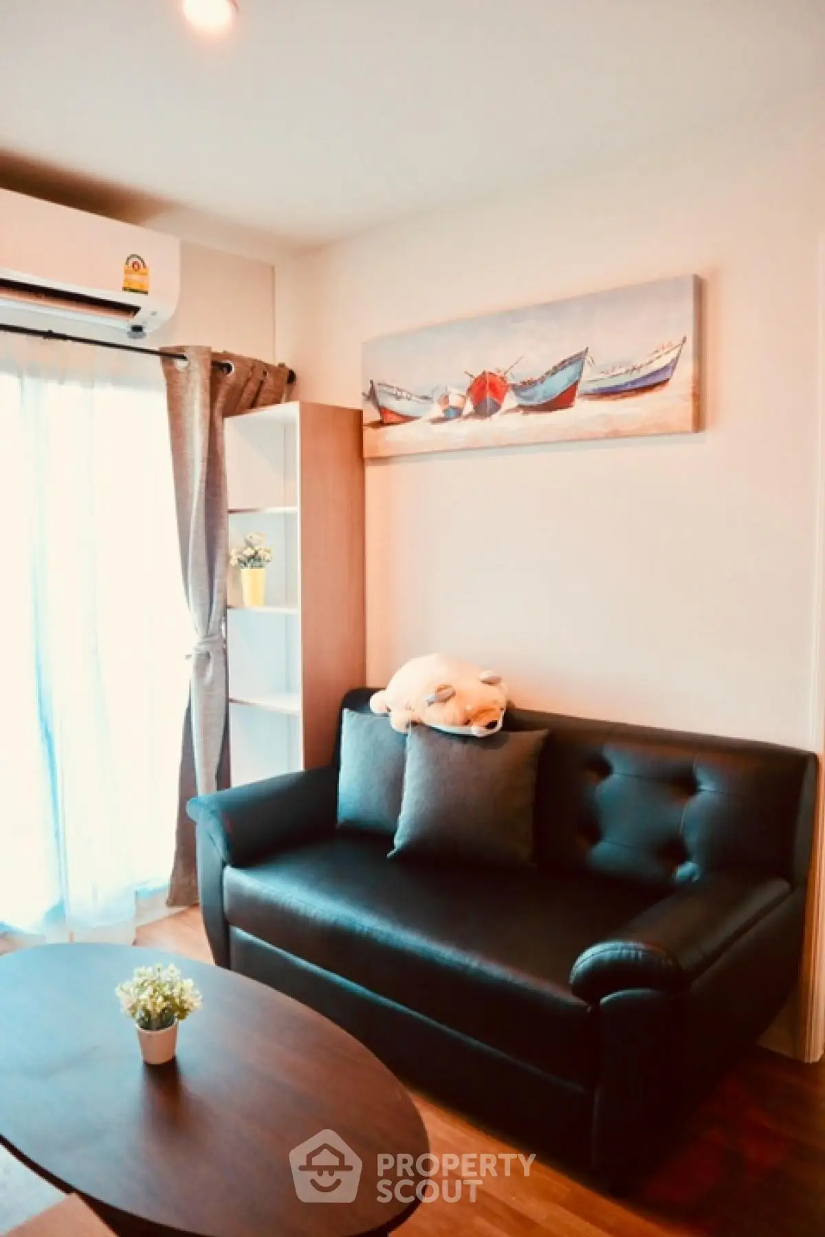 Cozy living room with black leather sofa and nautical decor