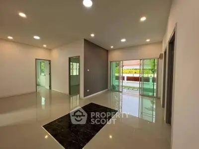 Spacious modern living room with glossy floors and large windows opening to a balcony.