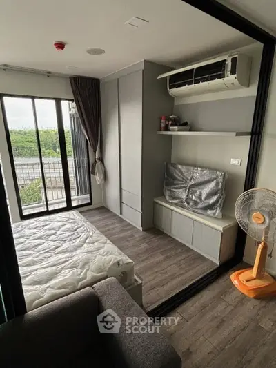 Modern bedroom with balcony access and air conditioning in urban apartment