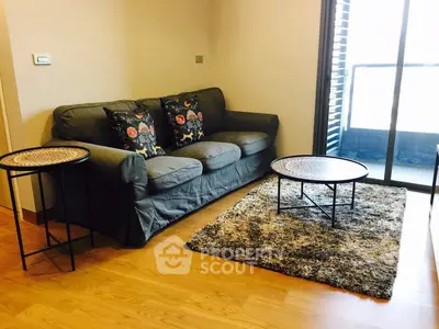 Cozy living room with stylish sofa and modern decor, featuring a plush rug and elegant coffee tables.