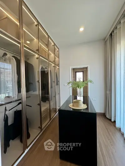 Luxurious walk-in closet with elegant wooden flooring and ample storage space