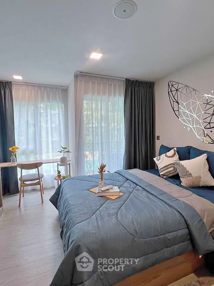 Modern bedroom with stylish decor and large windows offering natural light
