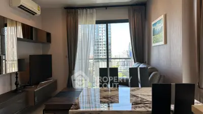 Modern living room with city view, featuring sleek furniture and large windows.