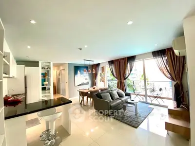 Spacious modern living room with open kitchen and balcony view, perfect for urban living.