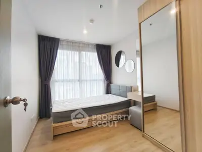 Modern bedroom with large window and mirrored wardrobe in stylish apartment