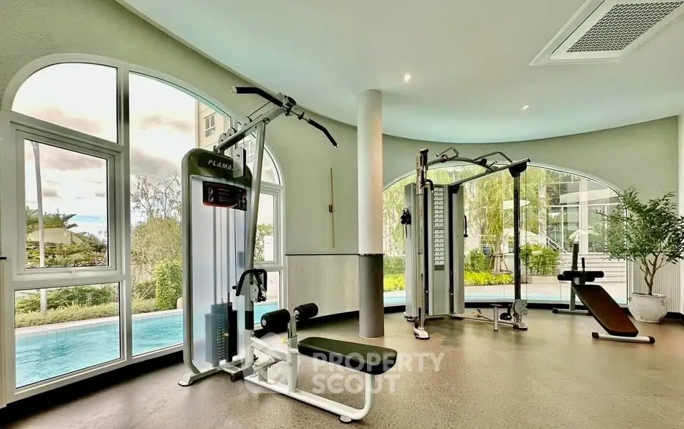 Luxurious gym with modern equipment and pool view in upscale property