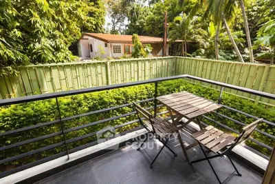 Charming balcony with lush garden view and cozy seating area